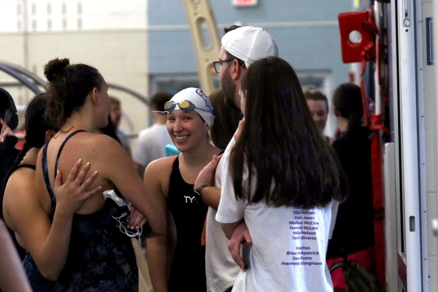 After the meet, sophomore Halle Nelson, junior Reagan Enemark and seniors Madison Mcclure and Torri Olivarez talk to head coach Brian Kirkpatrick. 