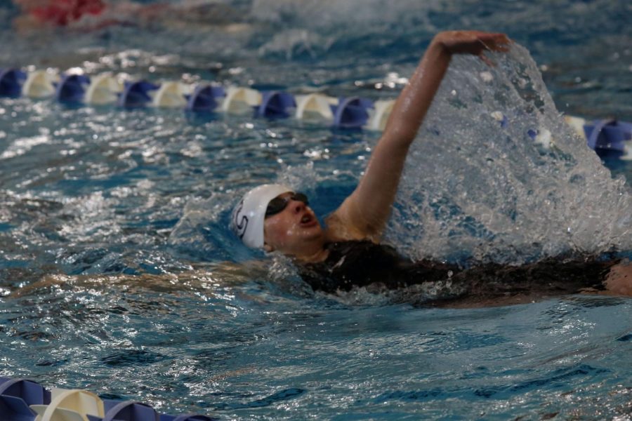 Breathing for air, freshman Claire Cooper backstrokes. 