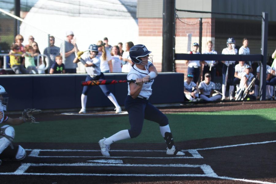 Watching the ball, junior Elly VanRheen swings her bat for the hit. 