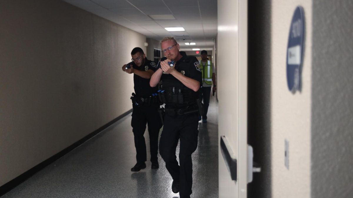 Advancing through the hallway, two officers make their way to the next classroom. 