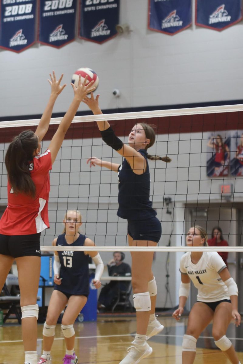 With her eyes on the ball, junior Saida Jacobs tries to tip the ball over the opposing teams block.