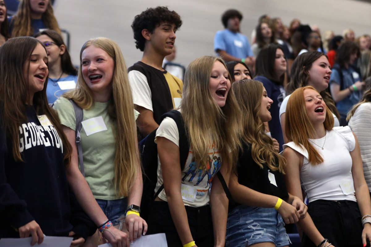 A group of freshmen cheer from the bleachers during the assembly. 