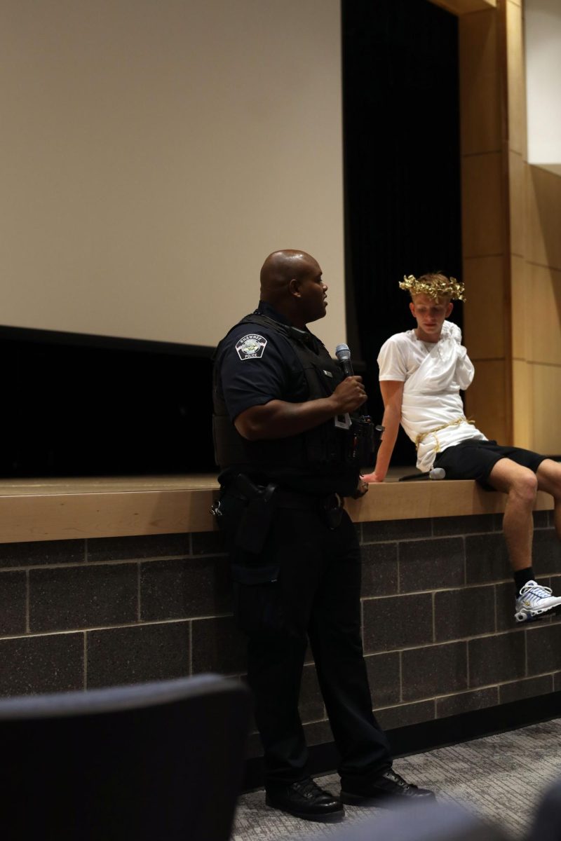 Talking to the audience, the new school resource officer, Darion Hillman, introduces himself. 