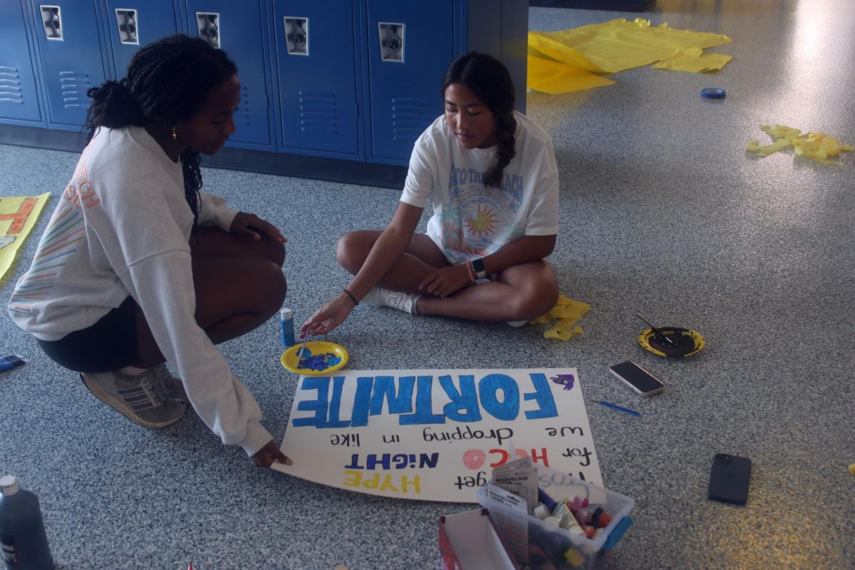 Collaboratively, freshmen Lyci Manirad and Biti Hasabu make a Fortnite-themed sign.