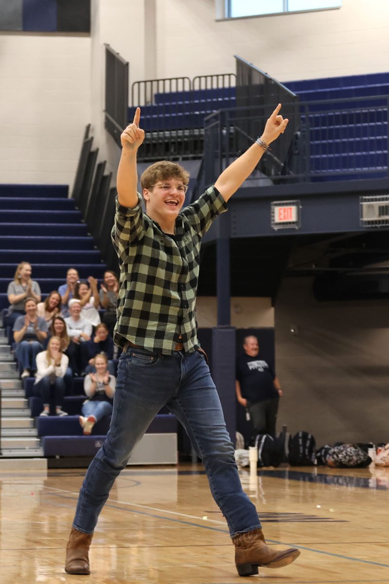 With a smile on his face, senior Blake Powers celebrates his and his partner, Homecoming candidate Lucy Roy, Tic-Tac-Toe win.