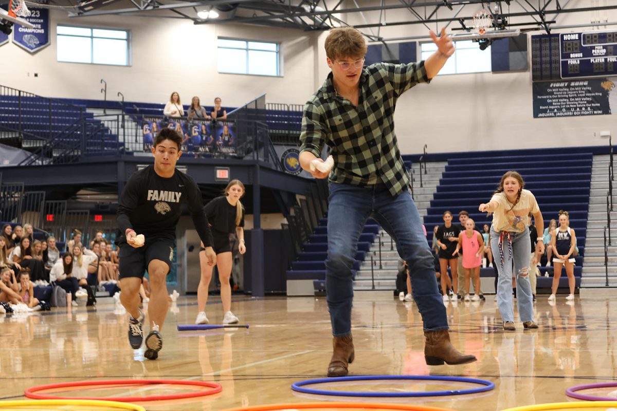 Searching the board, senior Blake Powers looks to toss his bean bag with his competition right behind him.