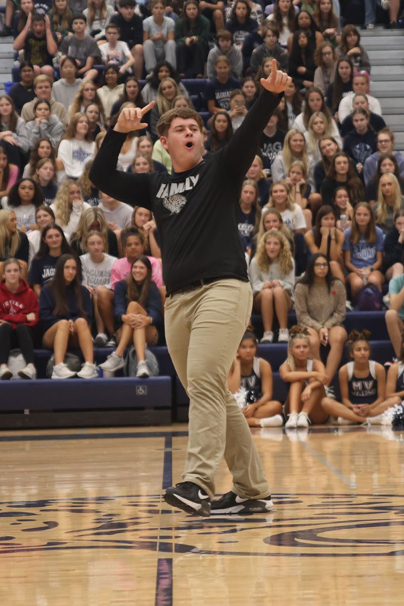 After performing his candidate handshake, senior Homecoming candidate Jack Fulcher points to the seniors in the stands.