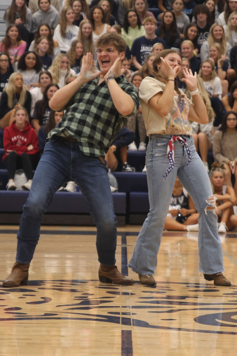 Dressed in cowboy outfits, senior Homecoming candidates Blake Powers and Lucy Roy sing along to “Pump It.”