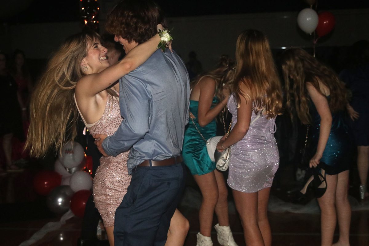 Smiling, sophomore Finley Rose dances with sophomore Presley Hartwig from Olathe Northwest at the homecoming dance.