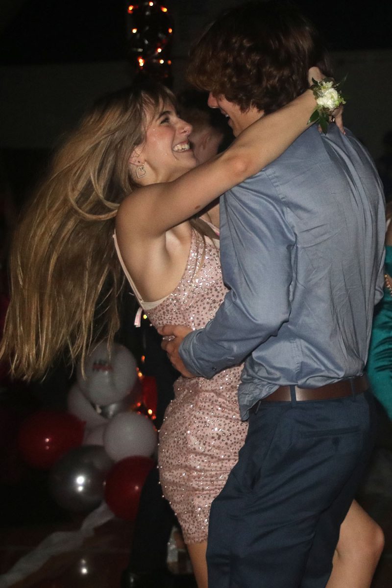 Smiling, sophomore Finley Rose dances with sophomore Presley Hartwig from Olathe Northwest at the homecoming dance.