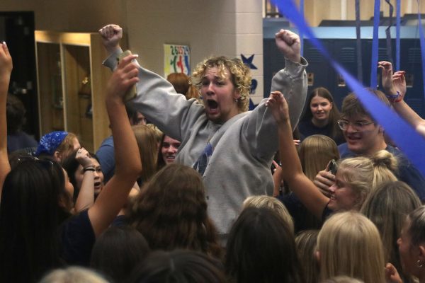 With his hands in the air senior Nate Garner dances in the middle of the blue bomb crowd.