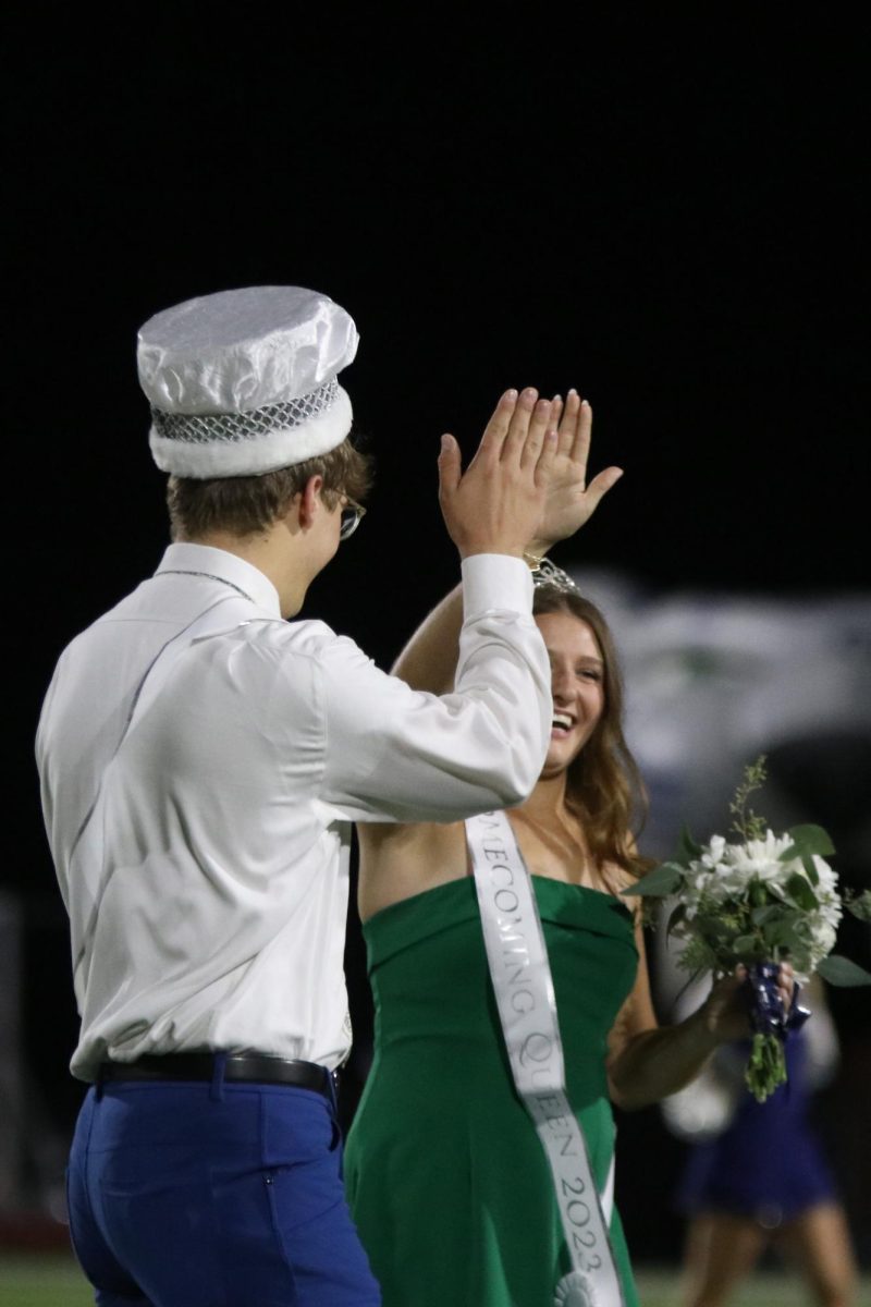 Seniors Lucy Roy and Blake Powers share a high five after being crowned as Homecoming king and queen.