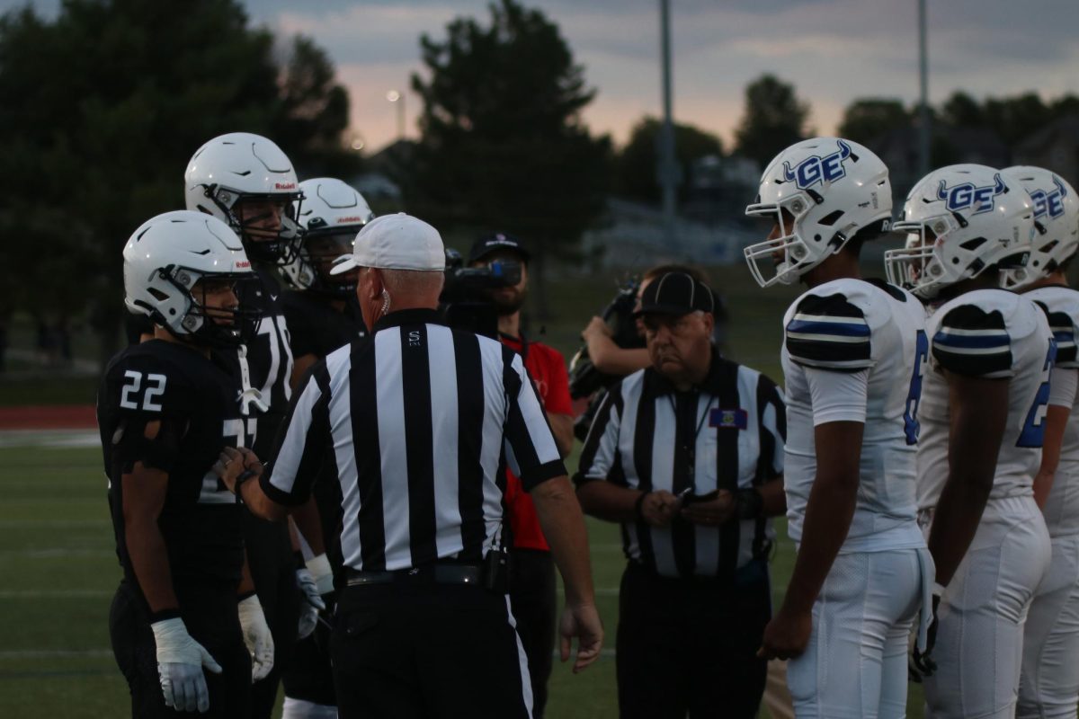Seniors Gus Hawkins and Evan Seifet, listen to the ref during the captains meeting and coin flip.