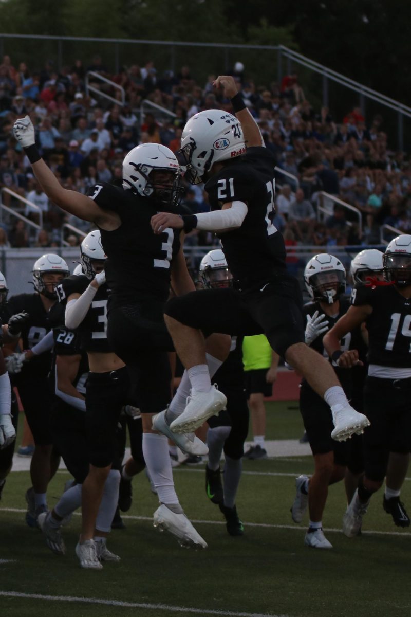 Excited for the game to begin, seniors Tristan Baker and Logan Holdren share a high five in the air.