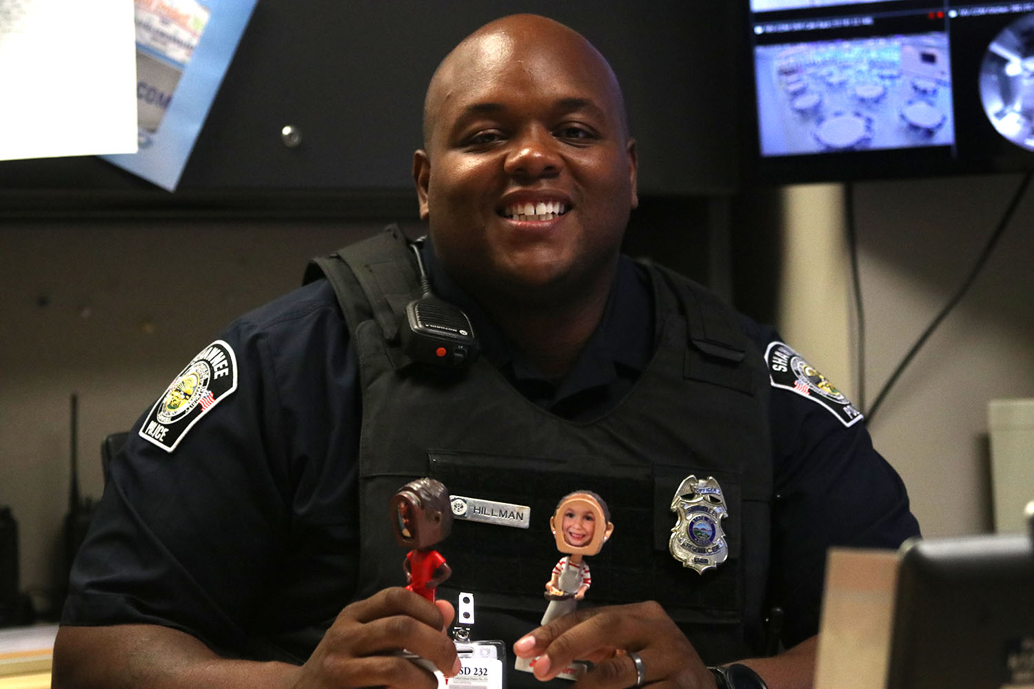 School Resource Officer Darion Hillman poses in his office. He describes his bobbleheads as the most important thing on his desk. I have my two little girls, Hillman said. This is Caitlin. Shes my one and a half year old and shes in a soccer bobblehead with her as a pitcher because I think shes more of my athlete and kind of tomboy and enjoys balls and sports. This is Kai, my four year old and she enjoys helping her mom and in the kitchen and kind of hanging out and going to dance class and those things.