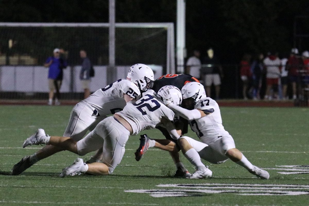 Seniors Waylon Schenk, Haden Applebee, and junior Garrett Clark work together to make a tackle. 
