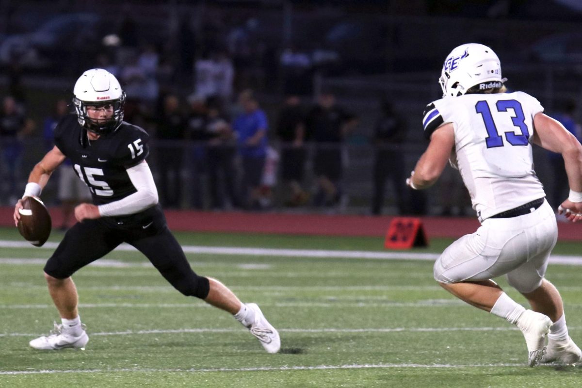 Running from a defender, senior Daniel Blaine attempts to recover from a failed pass play. 