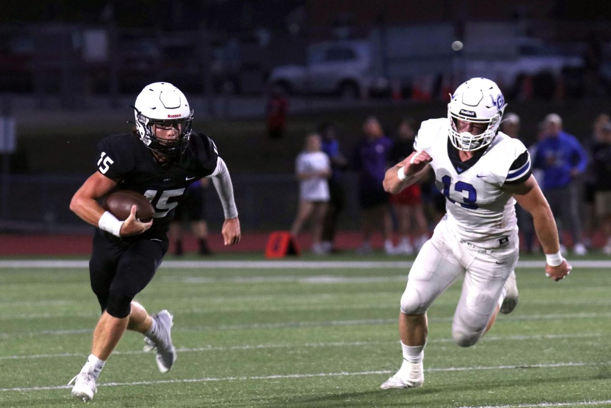 Maneuvering around a defender, senior Daniel Blaine fights for a first down.