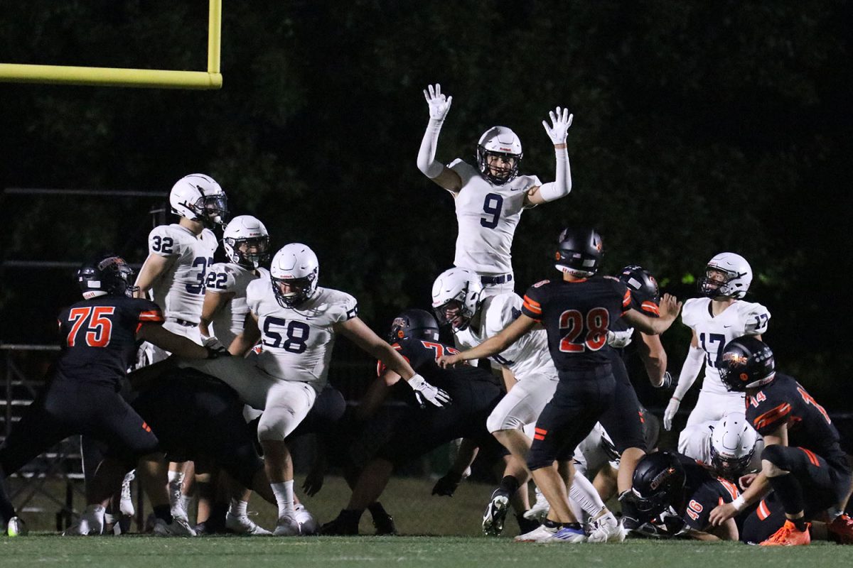 Senior Lincoln Gray jumps to block the extra point attempt by Shawnee Mission Northwest.