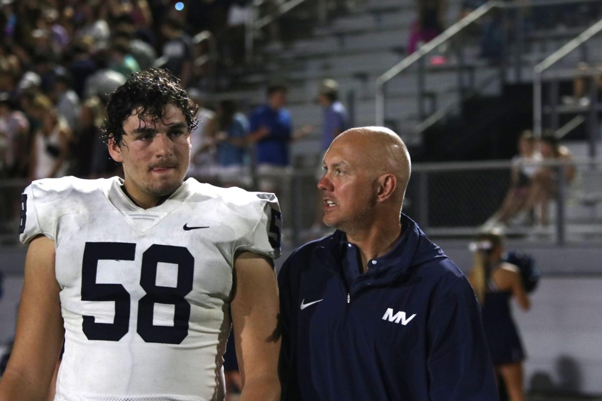 Defensive line coach Eric Thomas talks to junior Abram Shaffer. 