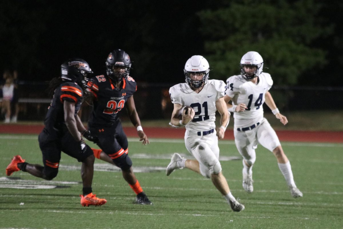 Senior Tristan Baker runs down the field after junior Connor Bohon hands the ball to him.
