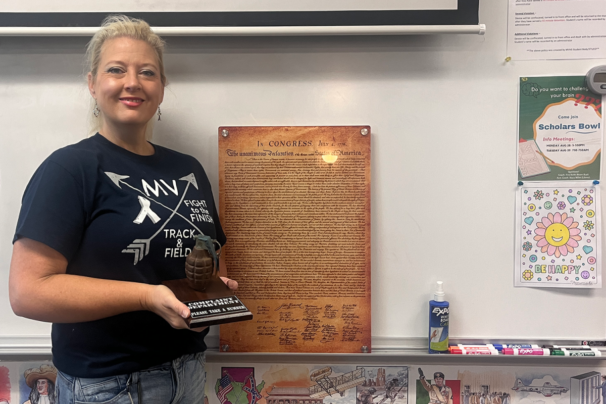 Social Studies teacher Tina Keith poses with her complaint department grenade Friday, Sep. 1. Its just an item of conversation, Keith said. Kids will come in and theyre like, “is that a real grenade,” and so thats something that Ive just always had with me. 