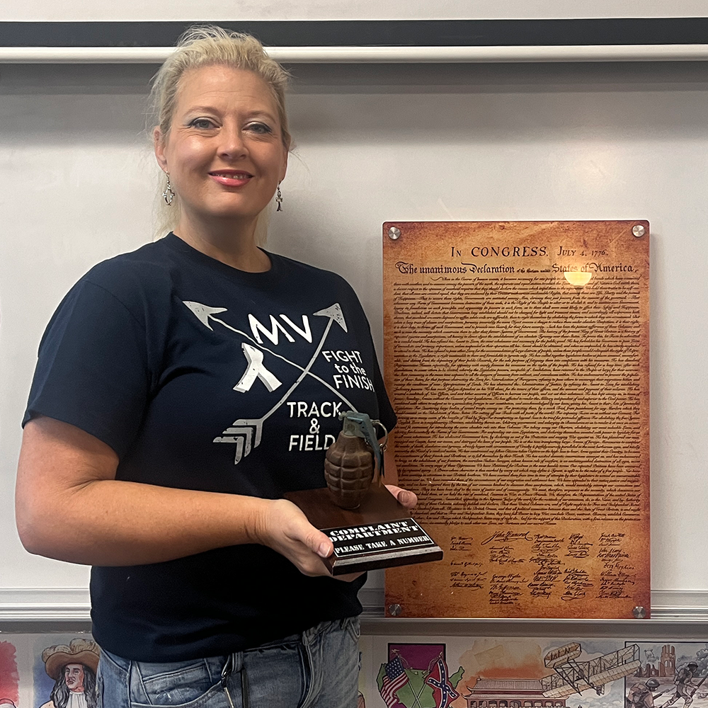 Social Studies teacher Tina Keith poses with her complaint department grenade Friday, Sep. 1. Its just an item of conversation, Keith said. Kids will come in and theyre like, “is that a real grenade,” and so thats something that Ive just always had with me. 