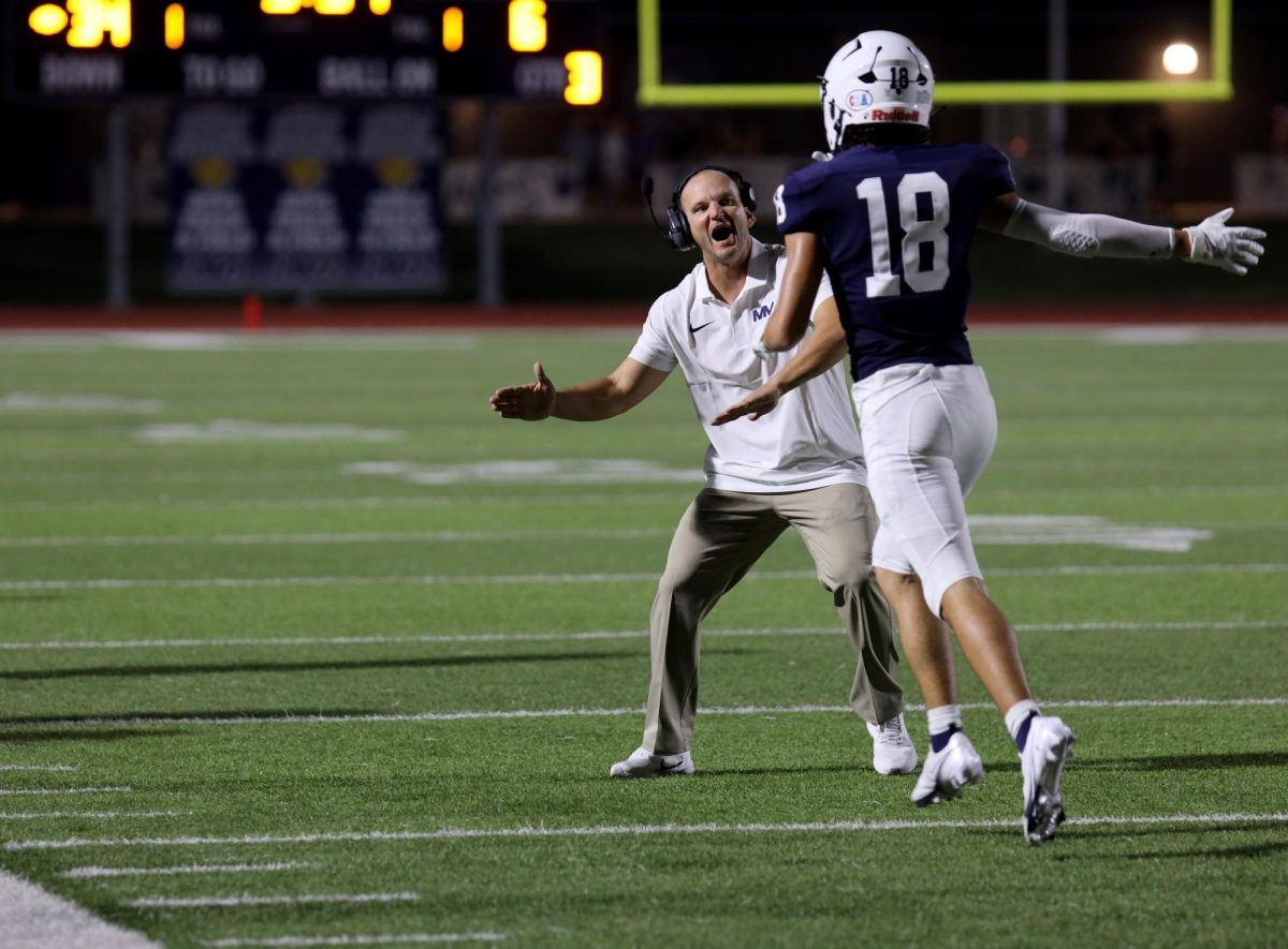 After a touchdown, junior Graeson Scott high fives Assistant Coach Jamie Resseguie.