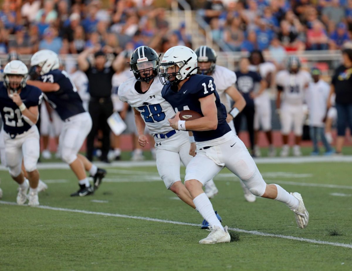 After the snap, junior Connor Bohon runs the ball.