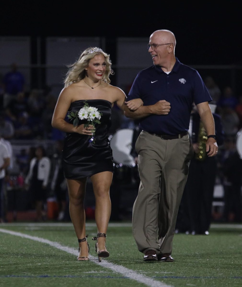 Senior Trinity Baker walks with her dad during coronation.
