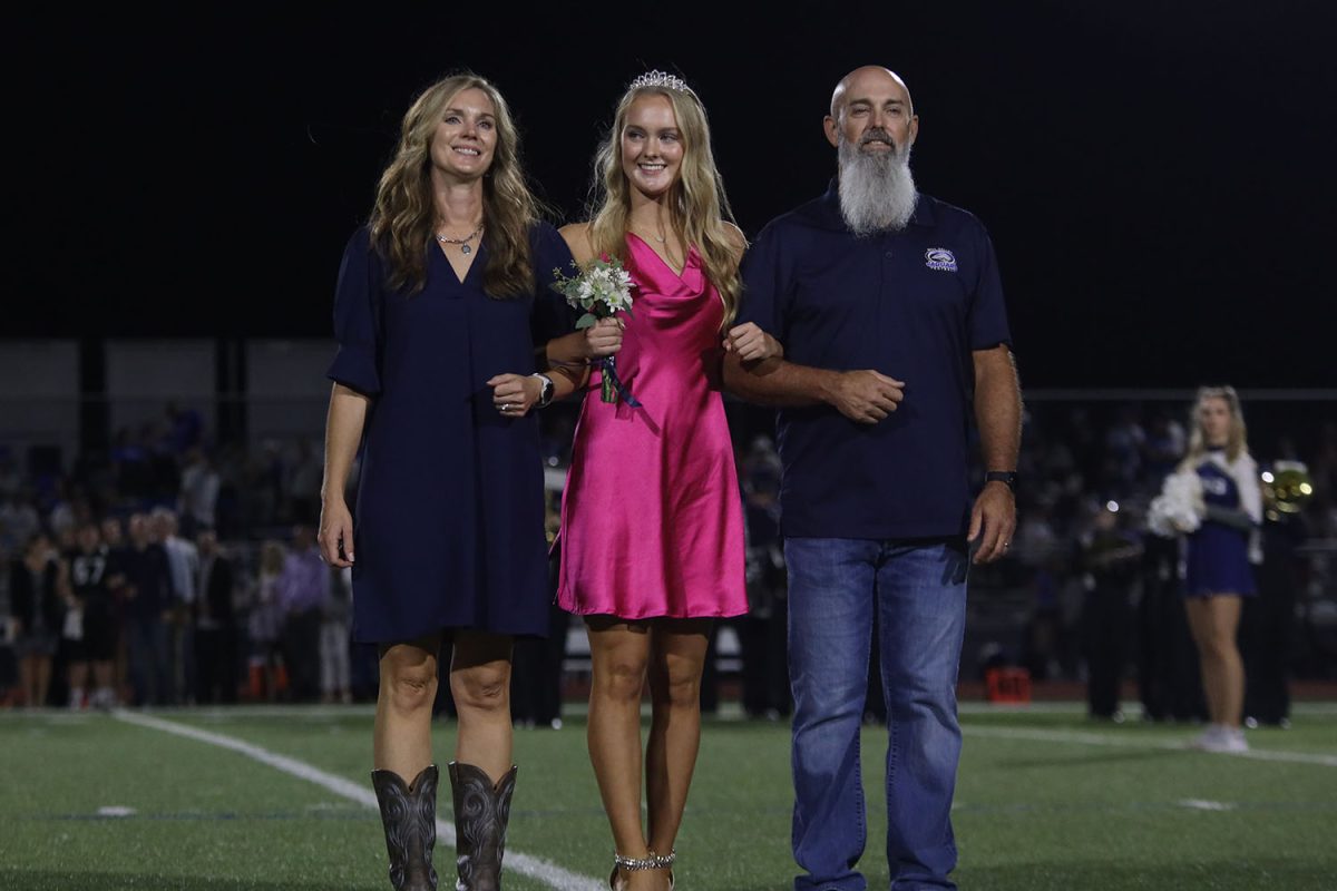 Senior Addison Bailey poses with her parents during coronation.
