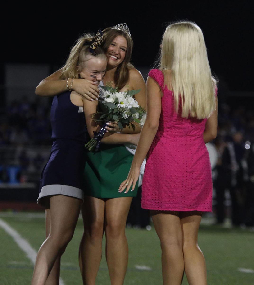 Senior Molly Morgan hugs Homecoming queen Lucy Roy after coronation.
