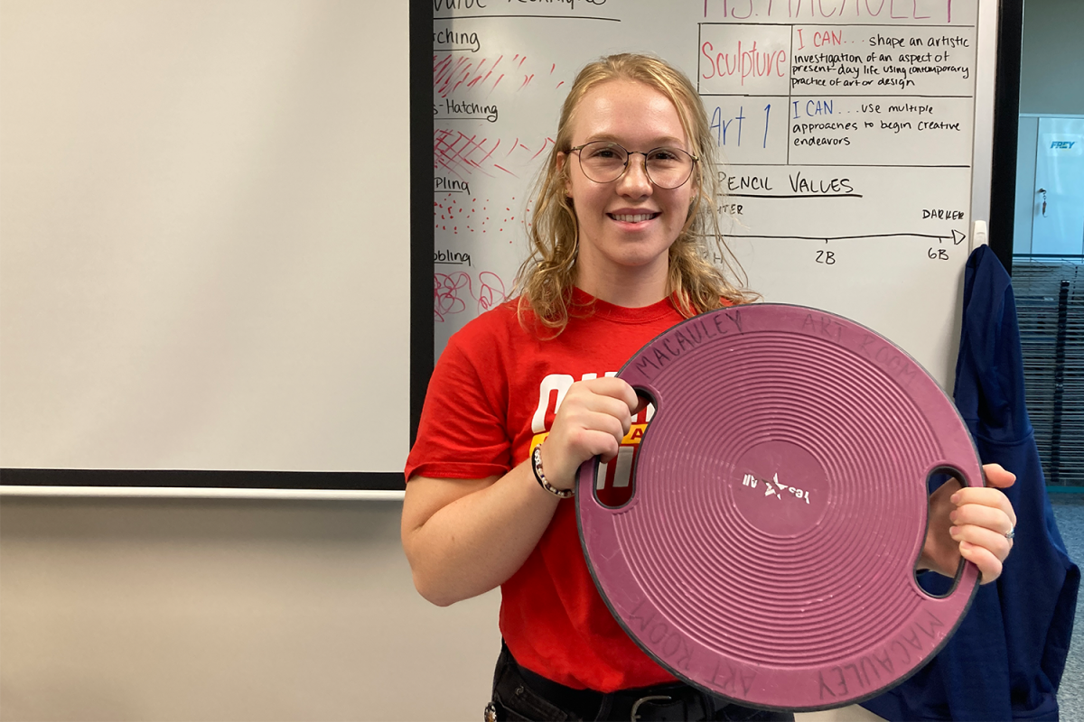 Art teacher Samantha MacAuley holds up her wobble board Tuesday, Sep. 5. I do have a wobble board in my classroom because I dont sit still very well, MacAuely said.