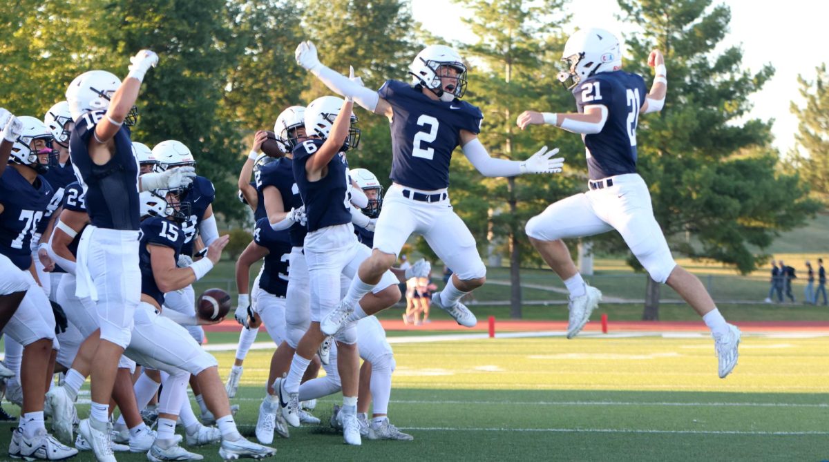 After the coin toss, seniors Tristan Baker and Jake Fischer jump and lock arms for the pregame hype ritual.