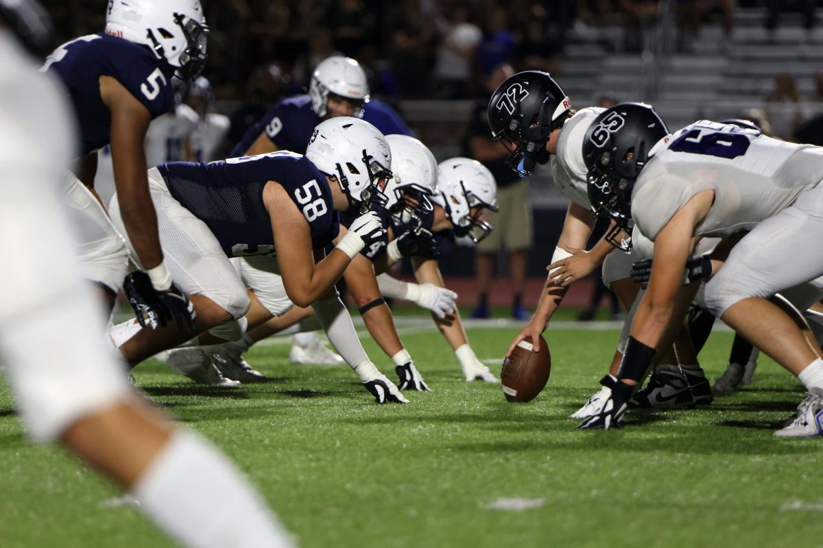 In their stances, the defensive line readies themselves to pressure the Olathe North West quarterback. 