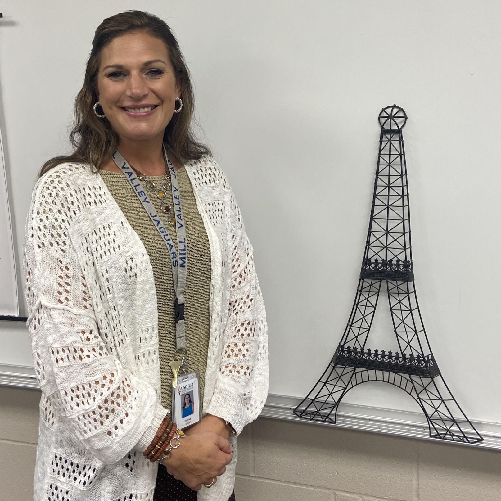 French teacher Denise Smith stands in front of her white board posing with her Eiffel tower wall decor. I used to have so much stuff, Smith said. I used to have so many Eiffel towers.