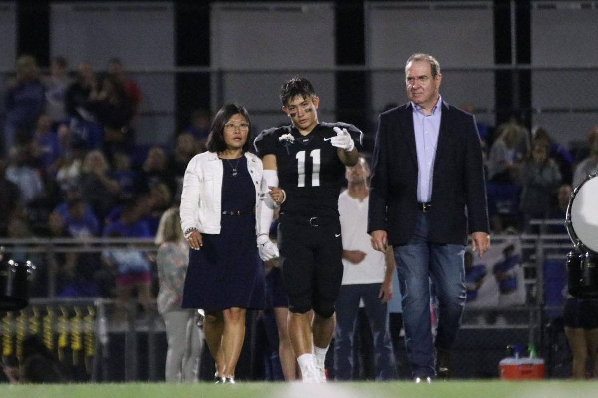 Senior Walt Midyett points and talks to his parents during coronation.