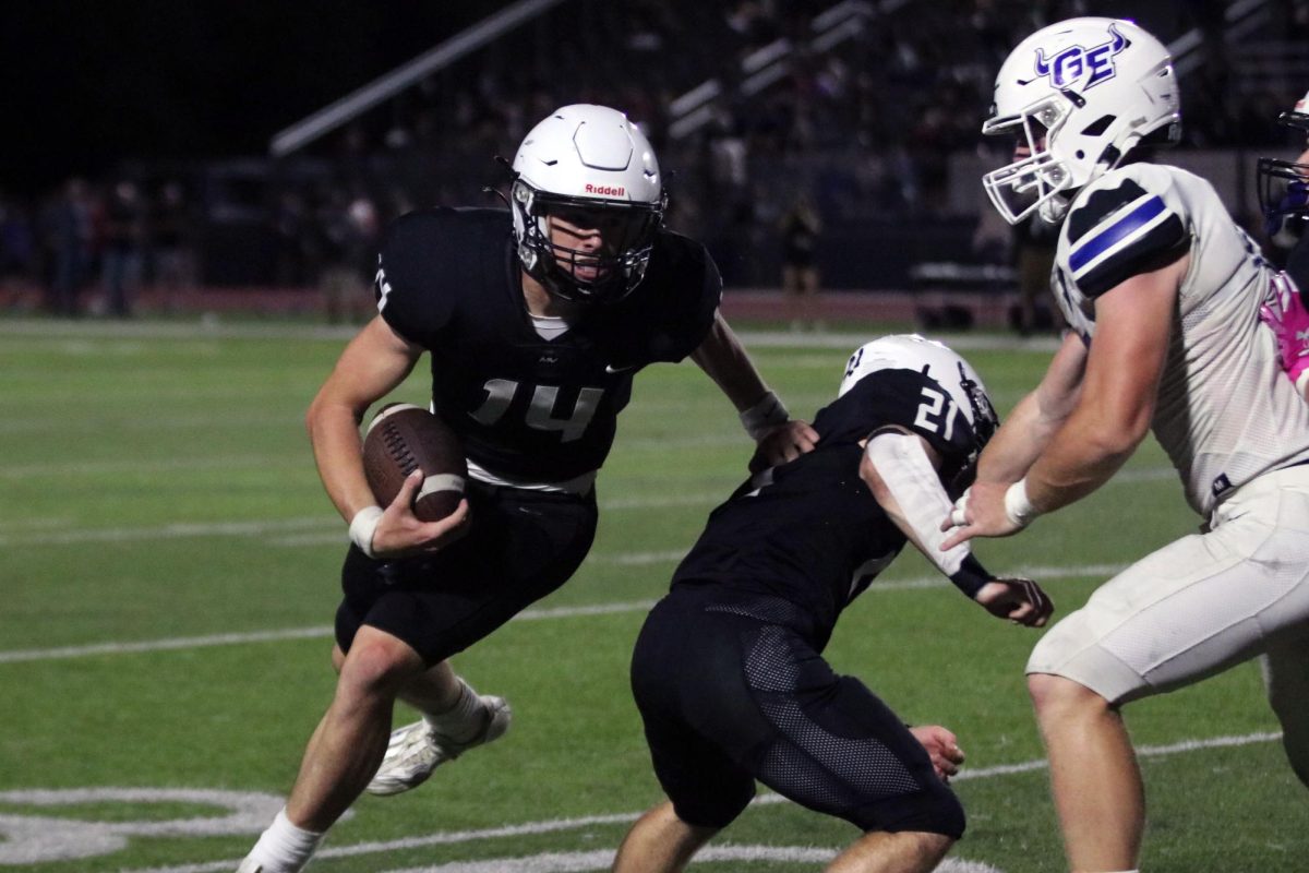 Running around his blocker, junior Connor Bohon carries the ball.