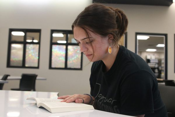 Senior Addisyn White grins as she reads “The Glass Castle” by Jeanette Walls, which she read the summer of her junior year for AP Language and Composition.