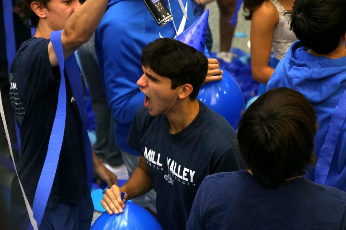 After blowing up a balloon, senior Liam Watson cheers. 