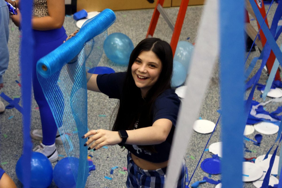 Smiling, senior Lydia Watson prepares to throw a roll of tulle. 