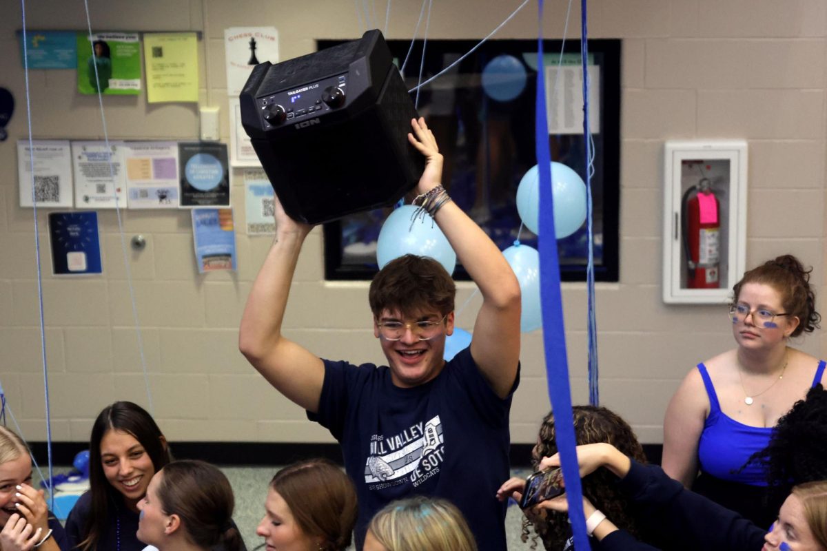 While dancing to the music, senior Blake Powers holds up the speaker. 