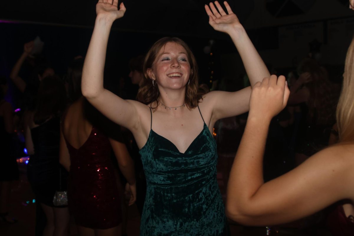 Jumping along to the music, junior Elly Hayes dances.