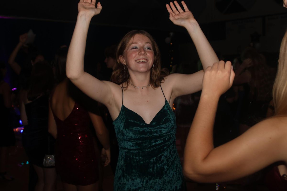 Jumping along to the music, junior Elly Hayes dances.
