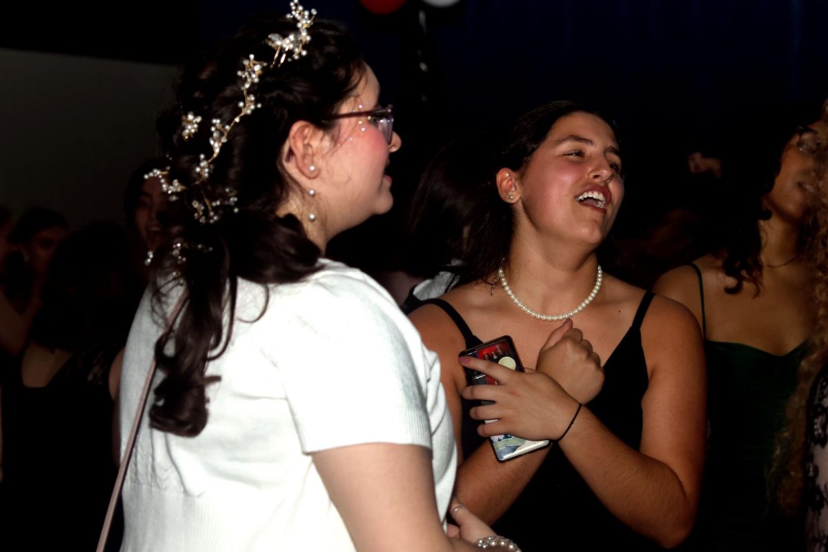 Enthusiastically, Junior Gillian Szymczak and Lacey Jennings sing together. 