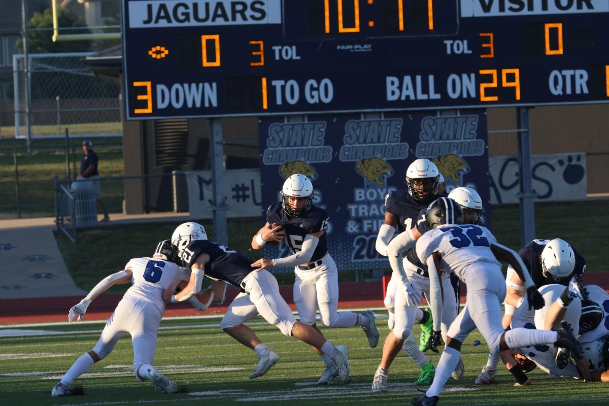 Senior Tristan Baker blocks his opponent so senior Daniel Blaine can run the ball.