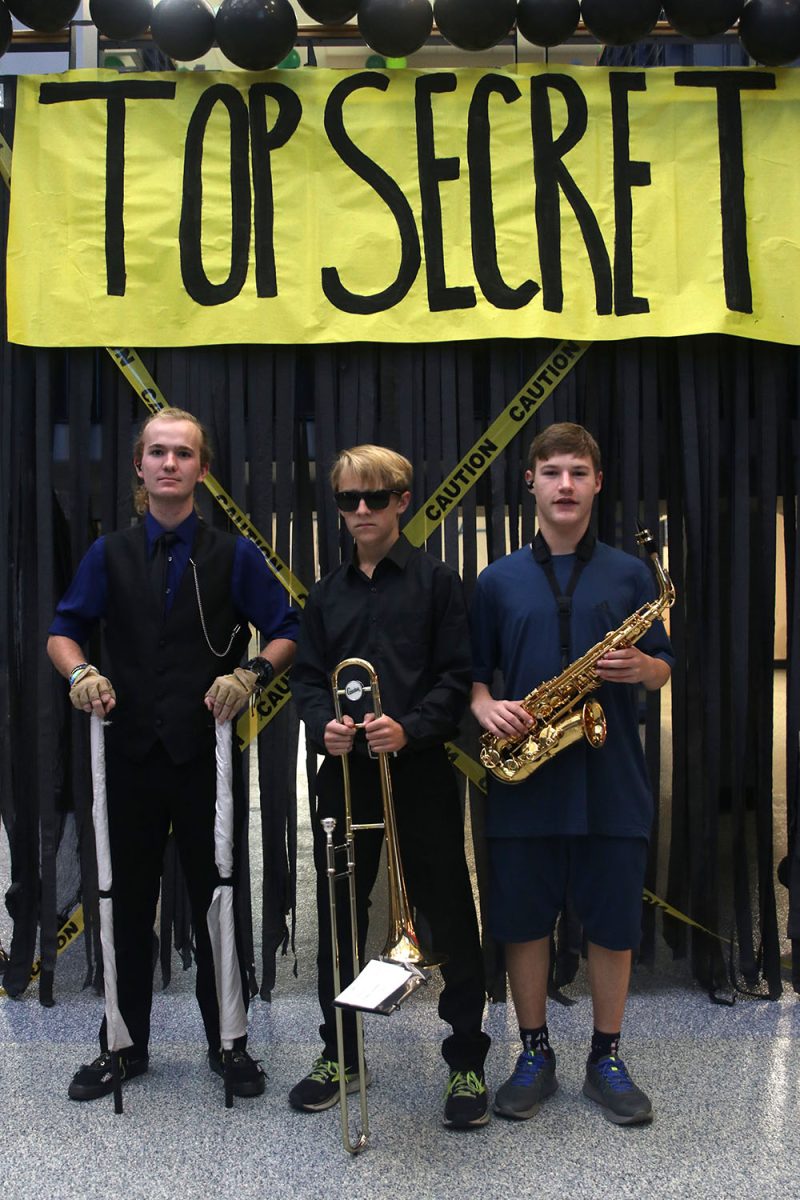 Strutting their suits and instruments, senior Evan Mack, sophomore Dillon Schmidtmann and freshman Grady Wilson pose for the Suits and Sunnies Spirit day.