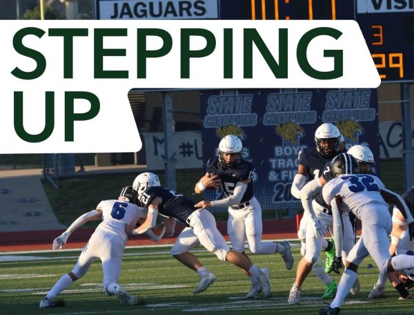 Senior Tristan Baker blocks his opponent so senior Daniel Blaine can run Friday, Sept. 2. Blaine is one of two starting quarterbacks for the team this year.