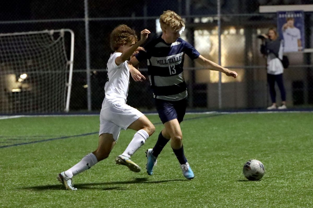 Defending the ball from, junior Drew Enloe steps in front of his opponent.