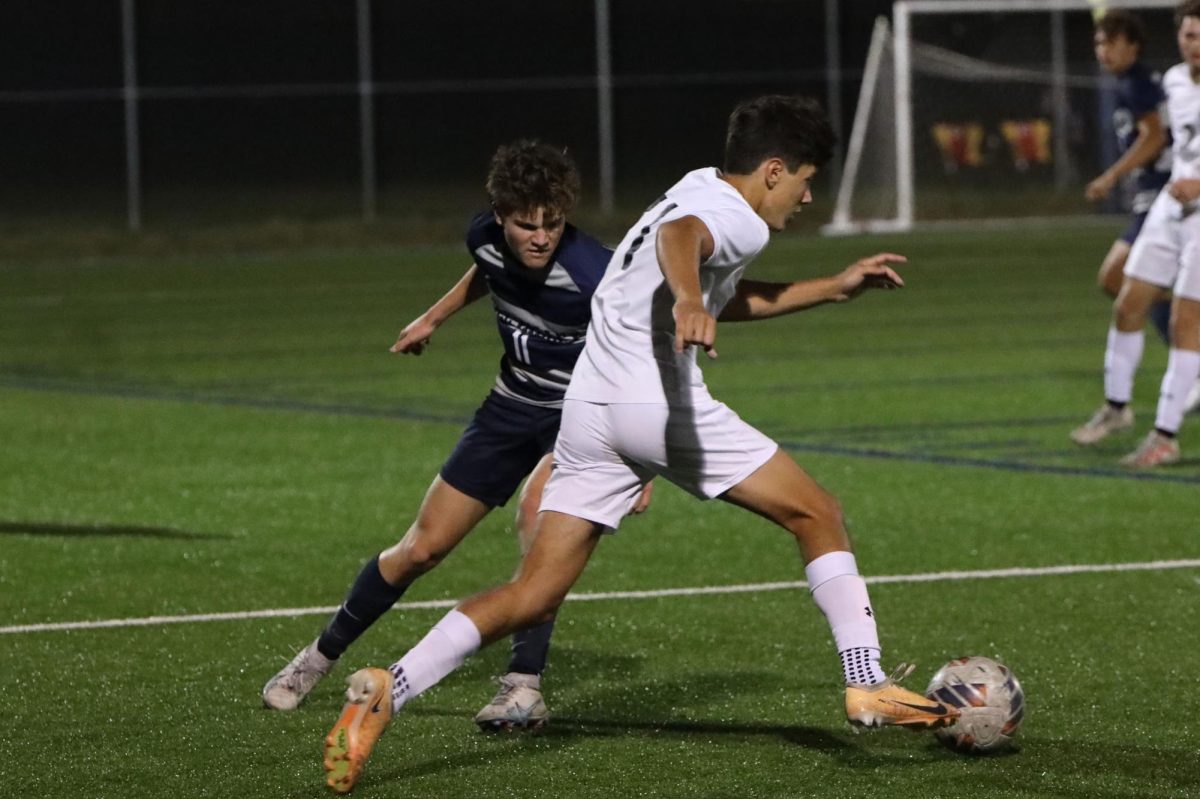 Fighting the other team for the ball, junior Joel Hays defends.